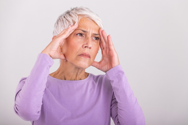 El ataque del monstruo de la migraña. Dolor de sinusitis. Infeliz mujer mayor jubilada sosteniendo su cabeza con expresión de dolor