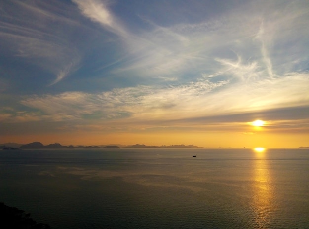 Atardecer ardiente con nubes junto al océano