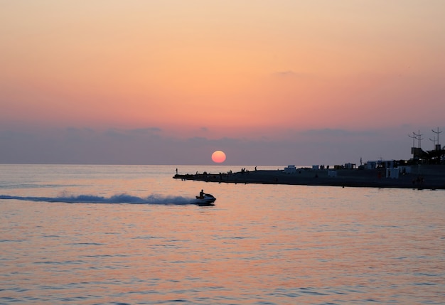 Atardecer en la costa con gente de descanso.