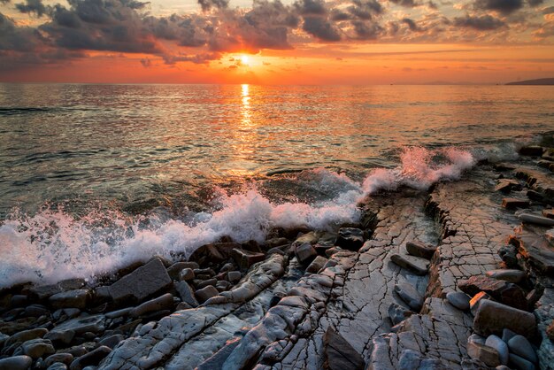 Atardecer en la costa del mar negro, surf y rocas