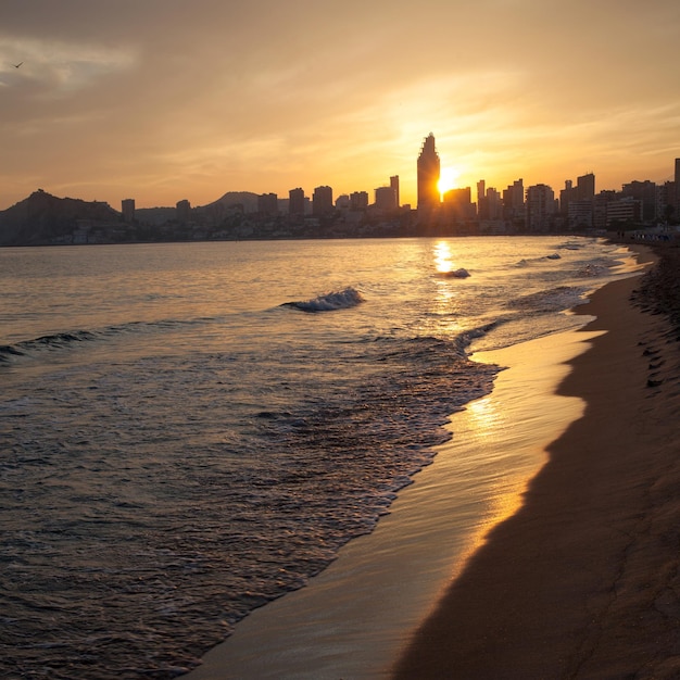 Foto atardecer dorado en la playa de poniente en benidorm, españa