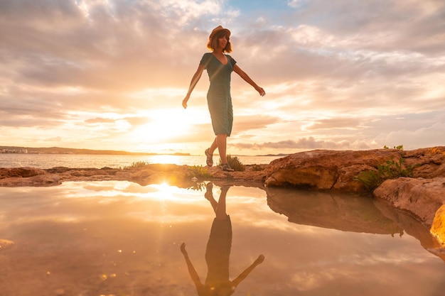 Atardecer en Ibiza un joven turista con sombrero de vacaciones en San Antonio Abad Balearic