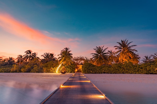 Atardecer en la isla de Maldivas, resort de lujosas villas acuáticas, muelle de madera cerrado. Increíble cielo colorido