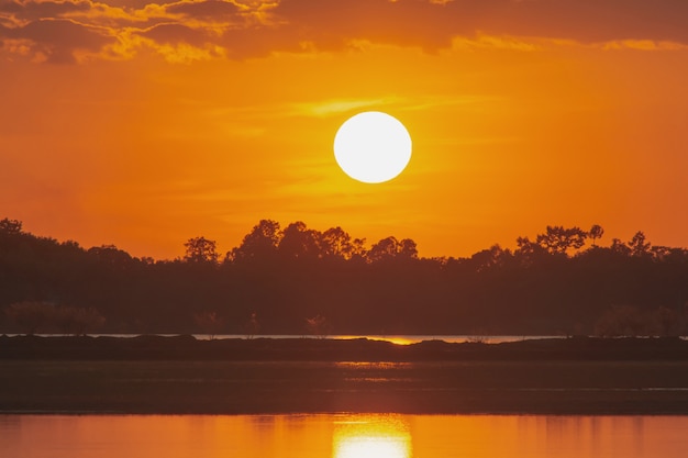 Atardecer en el lago. hermosa puesta de sol detrás de las nubes sobre el paisaje del lago