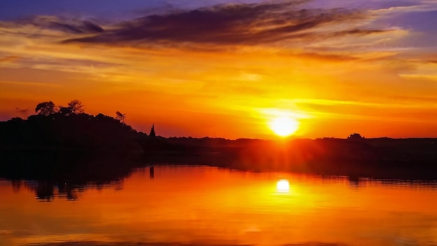 Foto un atardecer con un lago y una puesta de sol en el fondo