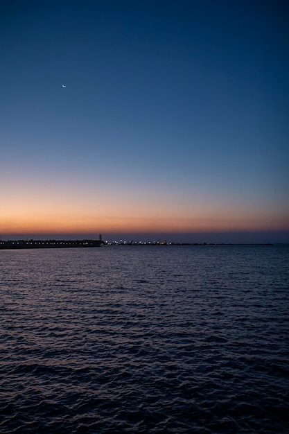 Foto un atardecer con luna en el cielo