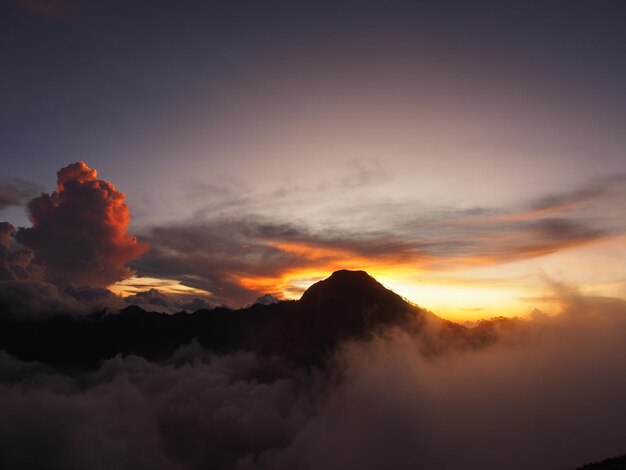 Un atardecer con una montaña al fondo