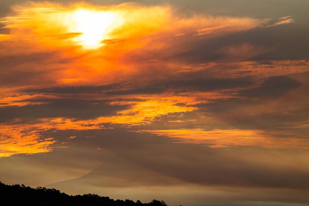 Un atardecer con una montaña al fondo