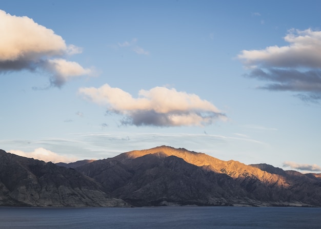 Foto atardecer y nubes sobre una cordillera.