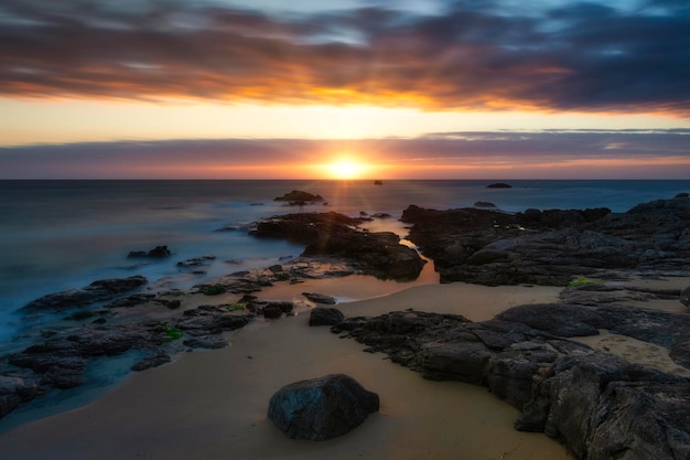 Atardecer o amanecer en la playa rocosa