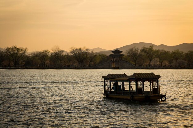 Atardecer en el Palacio de Verano de Pekín. Silueta del barco en el agua.