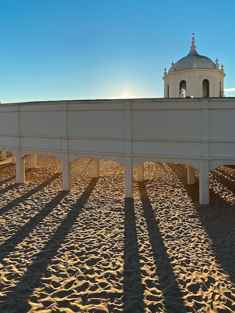 Atardecer en la playa La Caleta con el sol detrás de un antiguo edificio de madera en Cádiz España