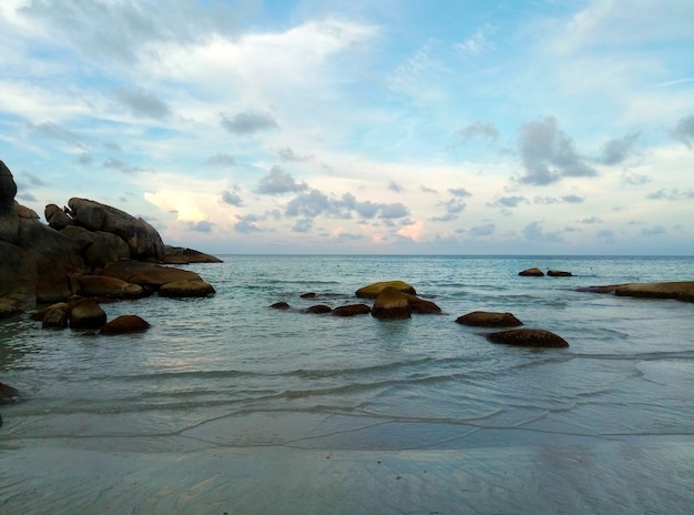 Atardecer en la playa de una isla tropical junto al océano.