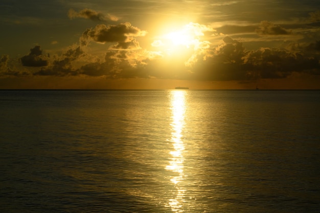 Atardecer en la playa del mar amanecer con cielo nublado