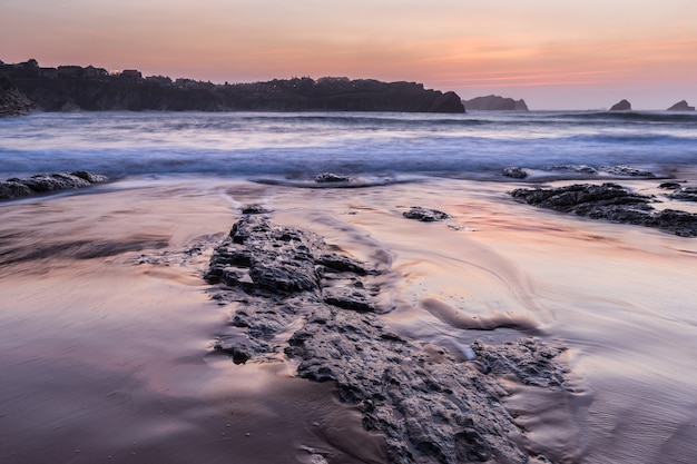 Foto atardecer en la playa de portio. liencres cantabria. españa.