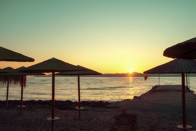 Atardecer en la playa con sombrillas