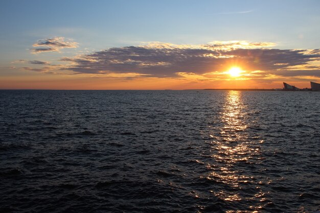 Atardecer de verano rojo en la zona de agua del golfo, un camino rojo soleado en el agua azul oscuro