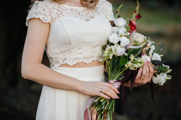 Atemberaubend schöner und stilvoller Hochzeitsstrauß hält die Braut Nahaufnahme. Floristisch