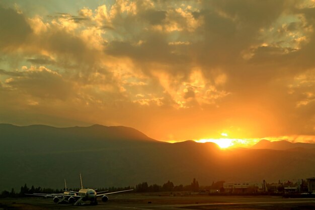 Atemberaubende Aussicht auf den Sonnenaufgang über den Bergketten mit der Landebahn des Flughafens im Vordergrund