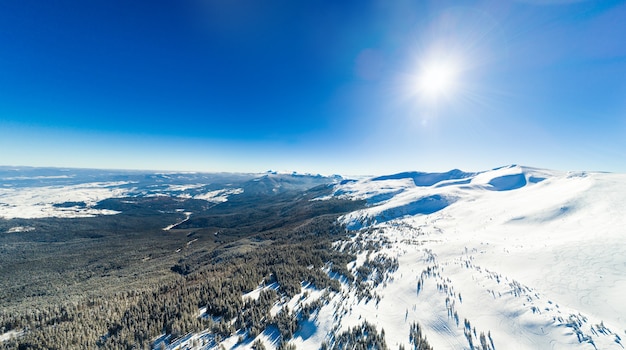 Atemberaubende Luftaufnahme der Bergketten an einem sonnigen frostigen Wintertag
