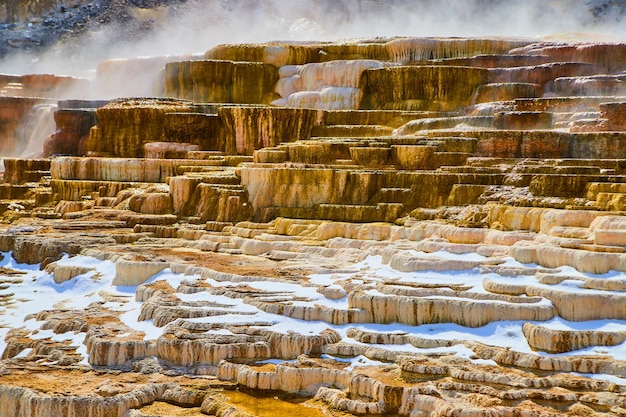 Atemberaubende Terrassenschichten in allen Farben in den heißen Quellen von Yellowstone mit Dampf