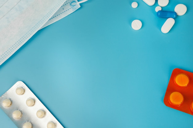 Atemmaske und Pillen auf blauem Hintergrund