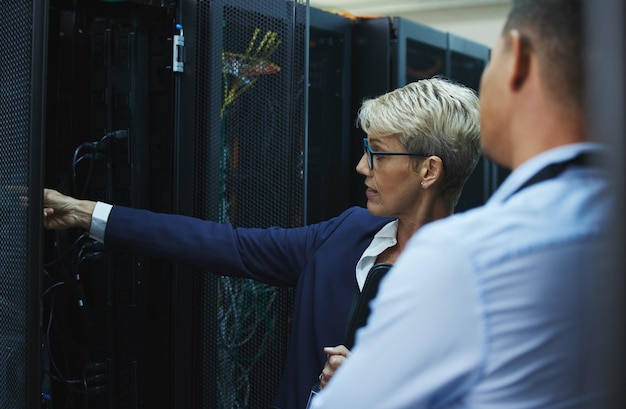 Atenção aos detalhes é o que faz um líder Foto de dois trabalhadores inspecionando o equipamento eletrônico em uma sala de servidores juntos no trabalho