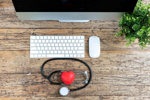 La atención médica es muy importante utilizando tecnología moderna para verificar la vista superior de la computadora del corazón rojo del estetoscopio de salud