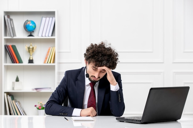 Atendimento ao cliente jovem bonito em terno de escritório com laptop e fone de ouvido pensando e confuso