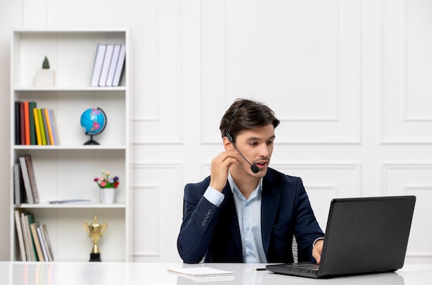 Atendimento ao cliente o cara morena bonito de terno com laptop e fone de ouvido