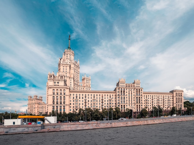 Aterro do rio moscou com edifício residencial stalinista contra o céu azul