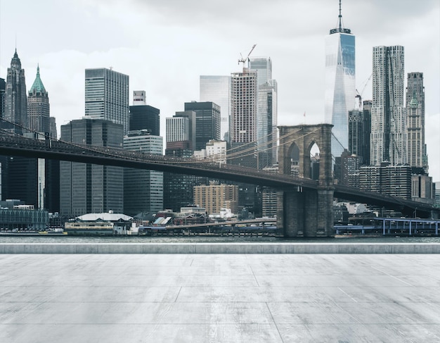 Aterro sujo de concreto vazio no fundo de um belo horizonte da cidade de NY e da ponte do Brooklyn na ma