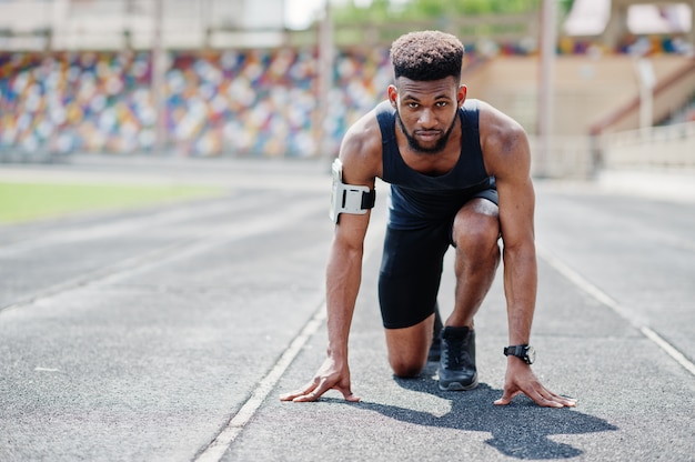 Athlet in Sportswear-Rennen alleine auf einer Laufstrecke im Stadion