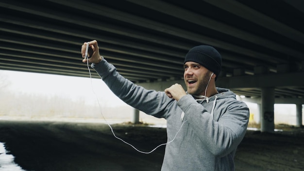 Athlet Mann mit Video-Chat auf dem Smartphone mit seinem Trainer nach dem Training in der Stadt