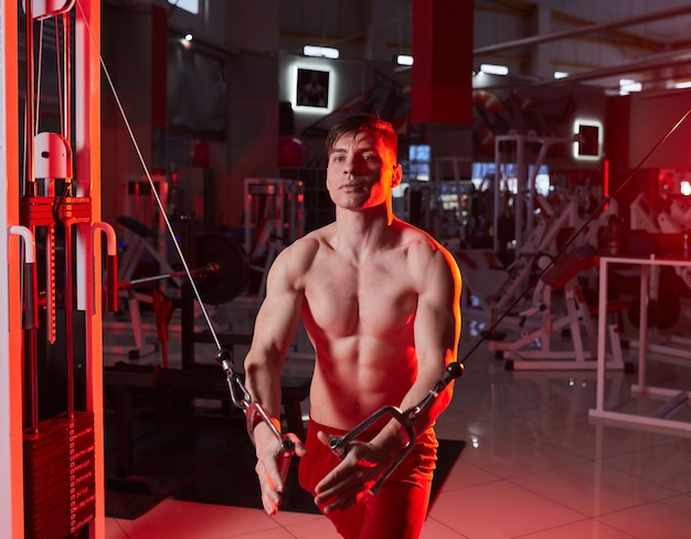 Athlet muskulöser Bodybuilder trainiert am Simulator im Fitnessstudio