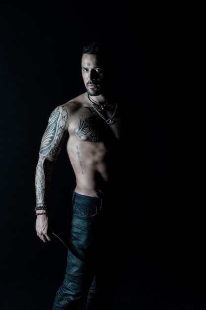 Athlet oder Sportler mit muskulöser Brust und Bauch Tattoo-Modell mit Sixpack und ab Bärtiger Mann mit tätowiertem Körper Mann mit sexy nacktem Oberkörper in Jeans Sport oder Fitness und Körperpflege