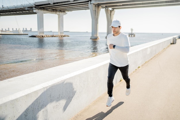 Athlet Running Man führt Fitnesstraining auf der Straße in der Stadt durch Gesunder Lebensstil