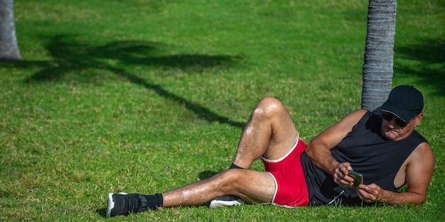 Athlet tippt auf einem Smartphone im Park