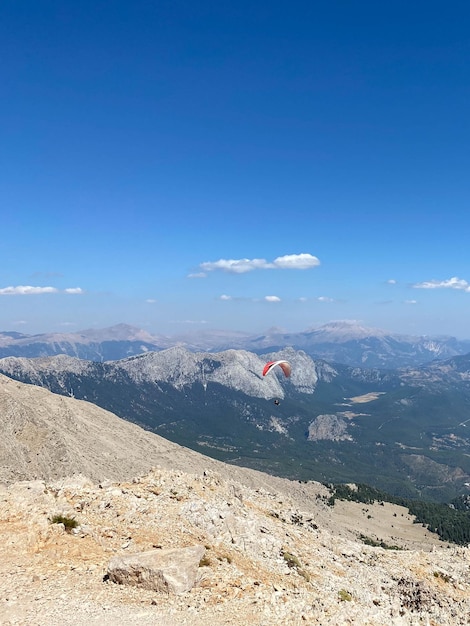 Athlet zusammen mit einem Touristen fliegt auf einem Gleitschirm vor dem Hintergrund eines bewölkten Himmels vorbei