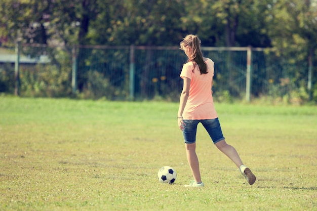 Athletenmädchen tritt den ball, der fußball gespielt wird.