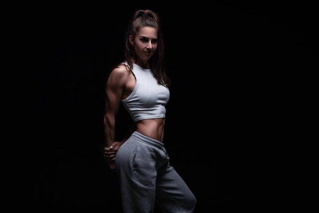 Athletic Fitness Frau posiert im Studio auf dunklem Hintergrund Foto einer attraktiven Frau in modischer Sportbekleidung Sport und gesunder Lebensstil