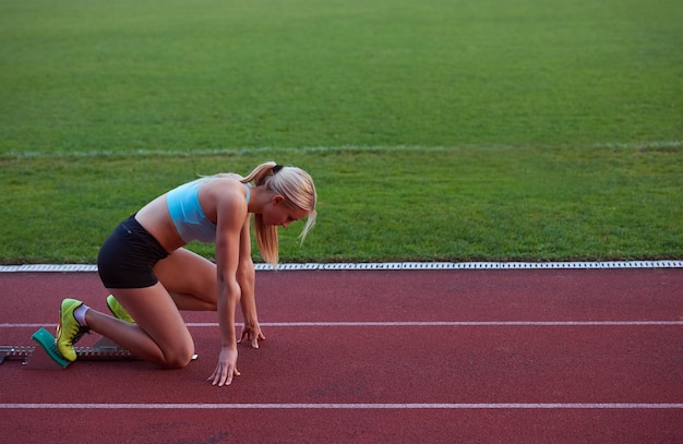 athletinnengruppe, die auf leichtathletik-rennstrecke im fußballstadion läuft und wettbewerbs- und führungskonzept im sport darstellt