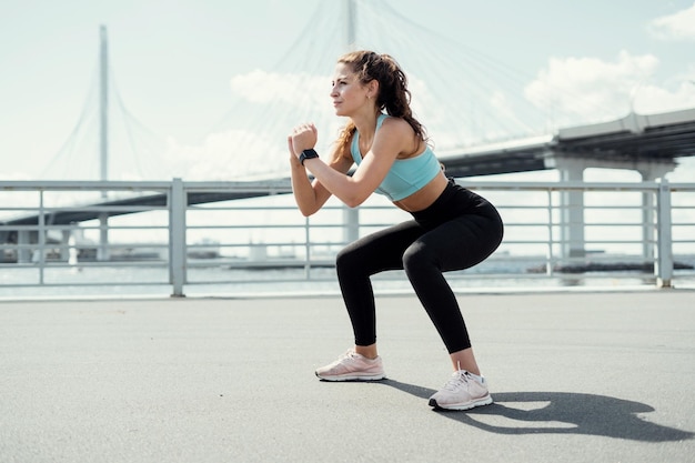 Athletisch selbstbewusste Frau aktives Outdoor-Training, das die Körpersportbekleidung dehnt und aufwärmt