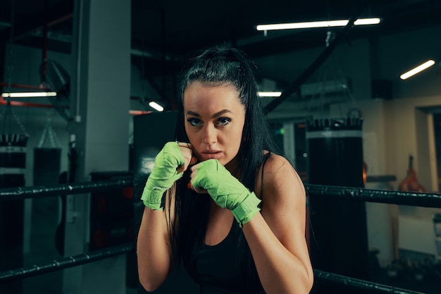 Athletische Frau, die während des Boxtrainings mit Boxbandagen an den Händen für den Kampf vorbereitet ist