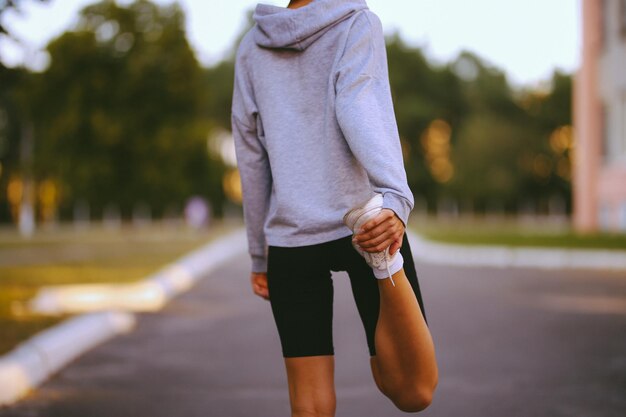 Athletische junge Frau, die sich mit Morgenübungen beschäftigt, Blick von der Rückseite der Vintage-Fotoverarbeitung