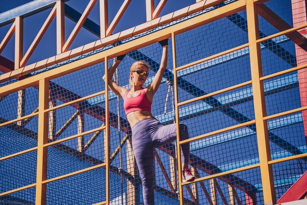 Foto athletische junge frau trainiert und klettert im trainingslager