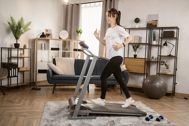 Athletische und muskulöse Frau trainiert aktiv in der modernen Wohnung