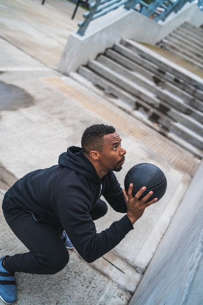 Athletischer Mann, der Wandballübung tut.