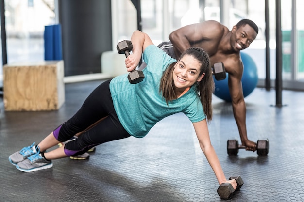 Athletischer mann und frau, die an crossfit turnhalle ausarbeitet