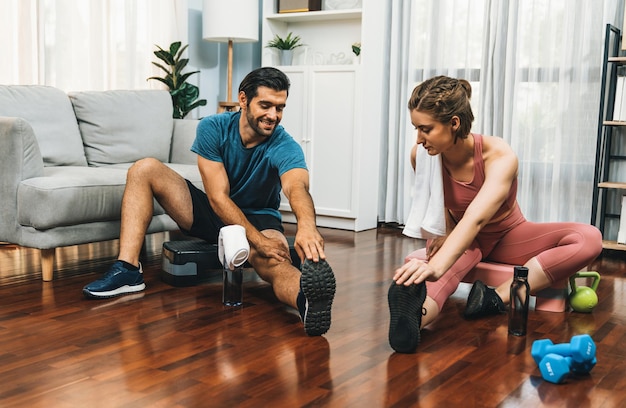 Foto athletisches körper und sportliches junges paar beim fröhlichen heimtraining